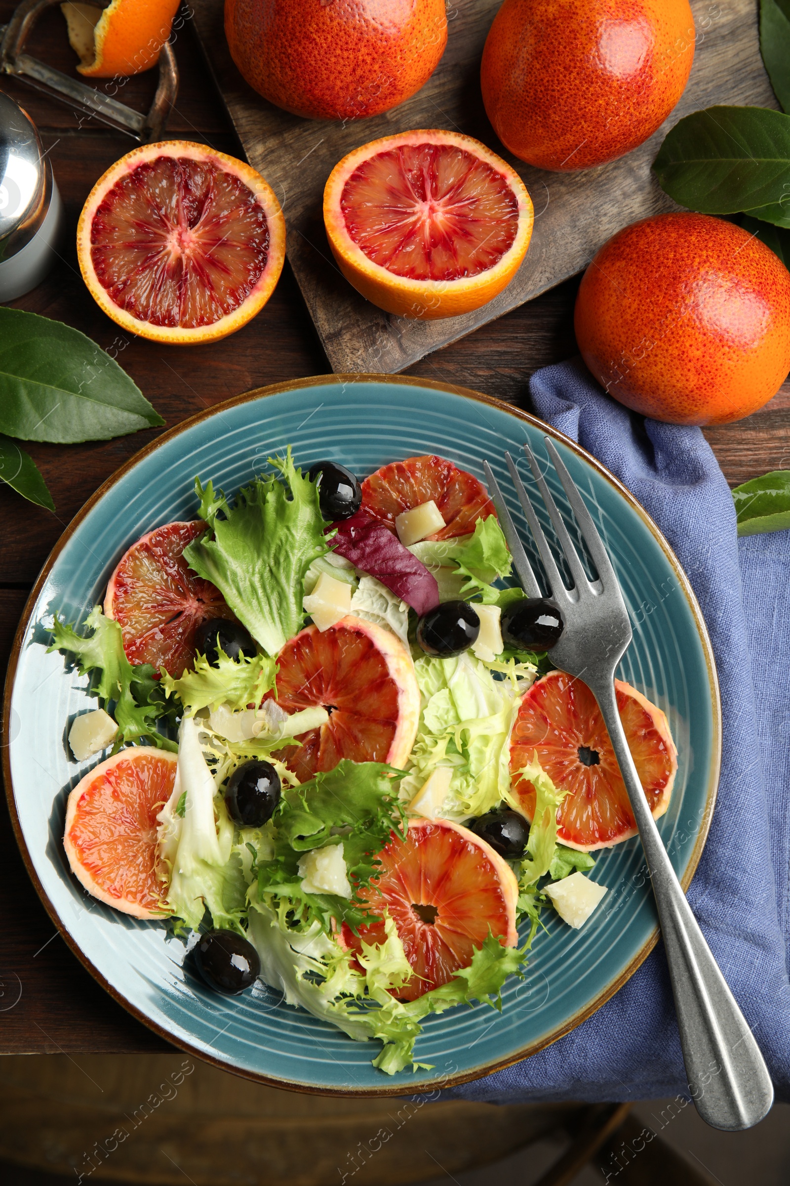 Photo of Delicious sicilian orange salad served on wooden table, flat lay