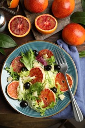 Photo of Delicious sicilian orange salad served on wooden table, flat lay