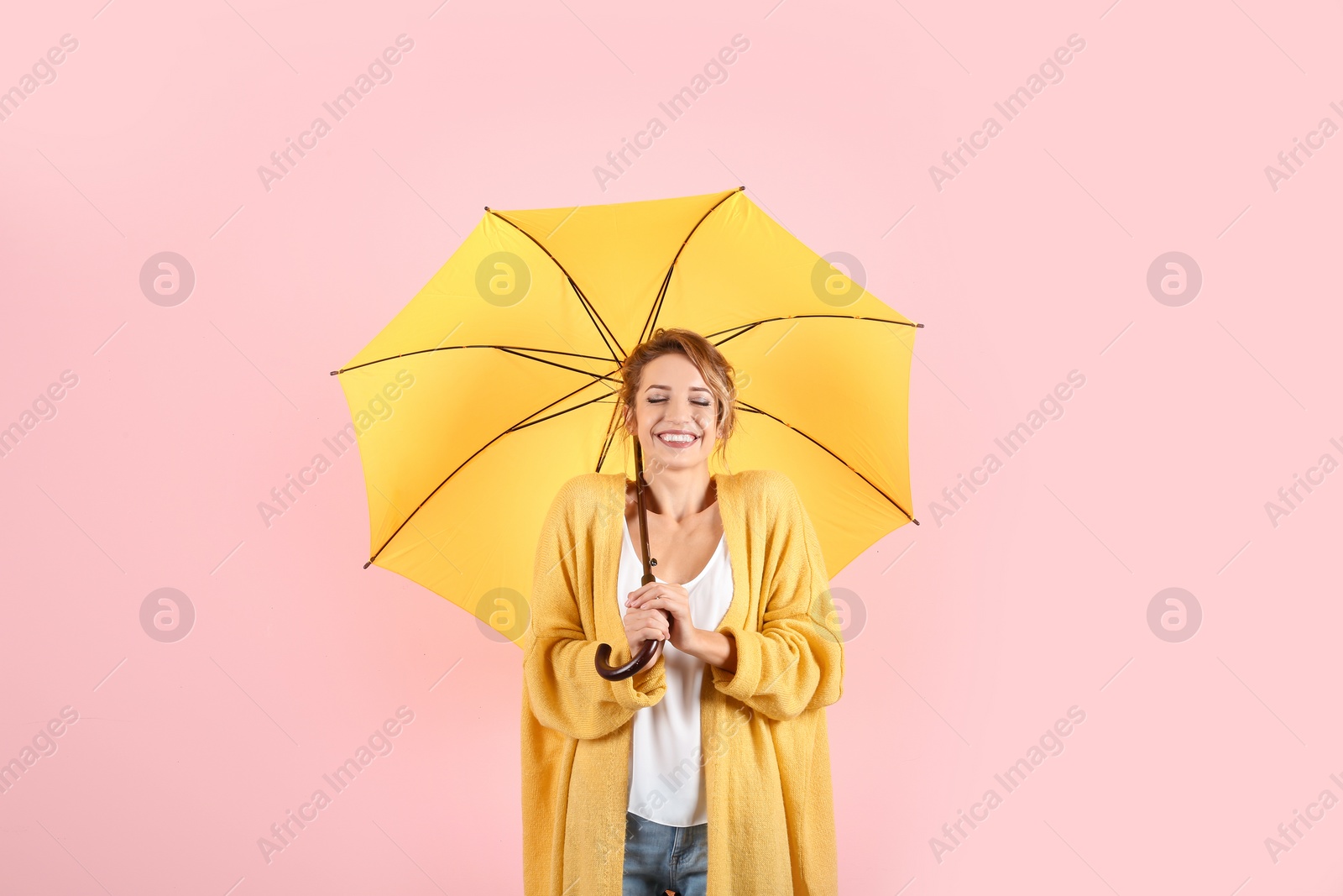 Photo of Woman with yellow umbrella on color background