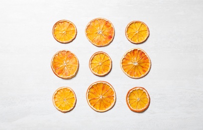 Dry orange slices on light table, flat lay