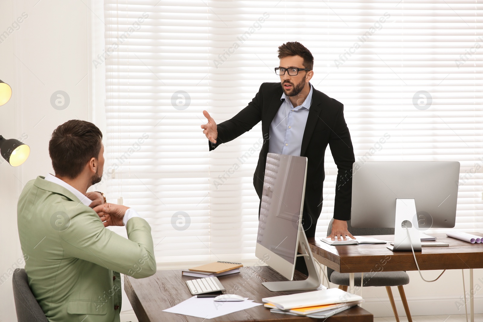 Photo of Emotional colleagues arguing in office. Toxic work environment