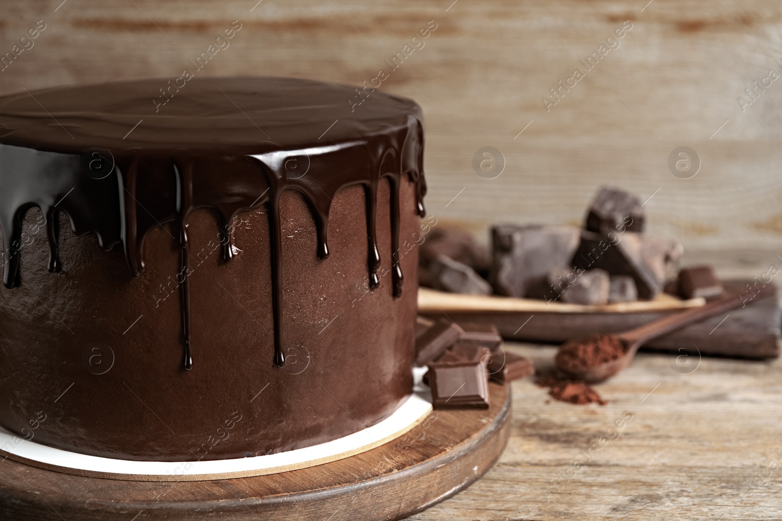 Photo of Freshly made delicious chocolate cake on wooden table, closeup. Space for text