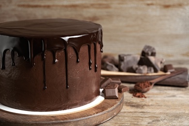 Photo of Freshly made delicious chocolate cake on wooden table, closeup. Space for text