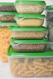 Photo of Plastic containers filled with food products on white table