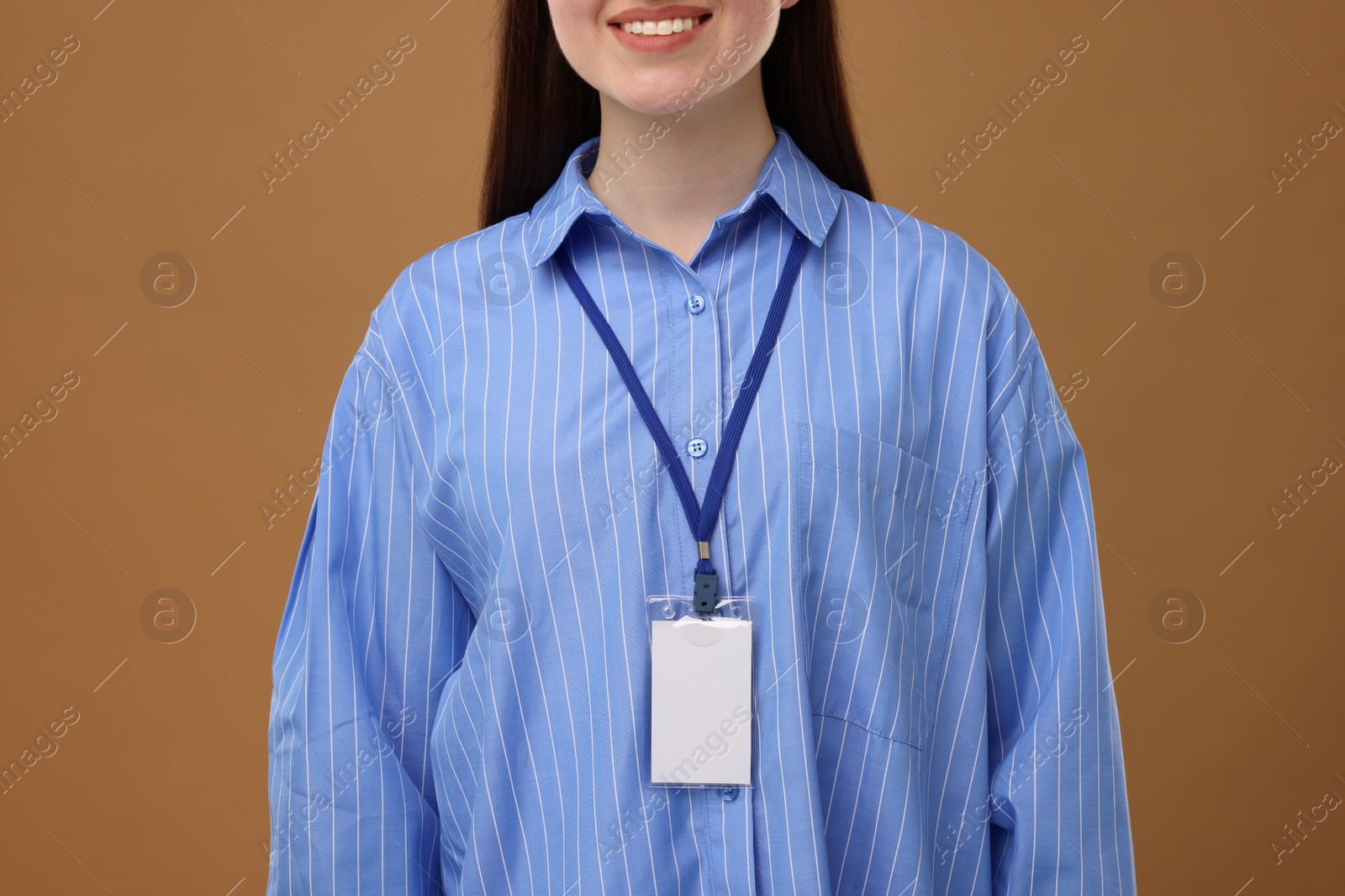 Photo of Woman with blank badge on brown background, closeup