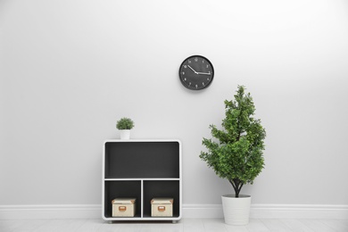 Office interior with houseplants and clock on wall. Time management