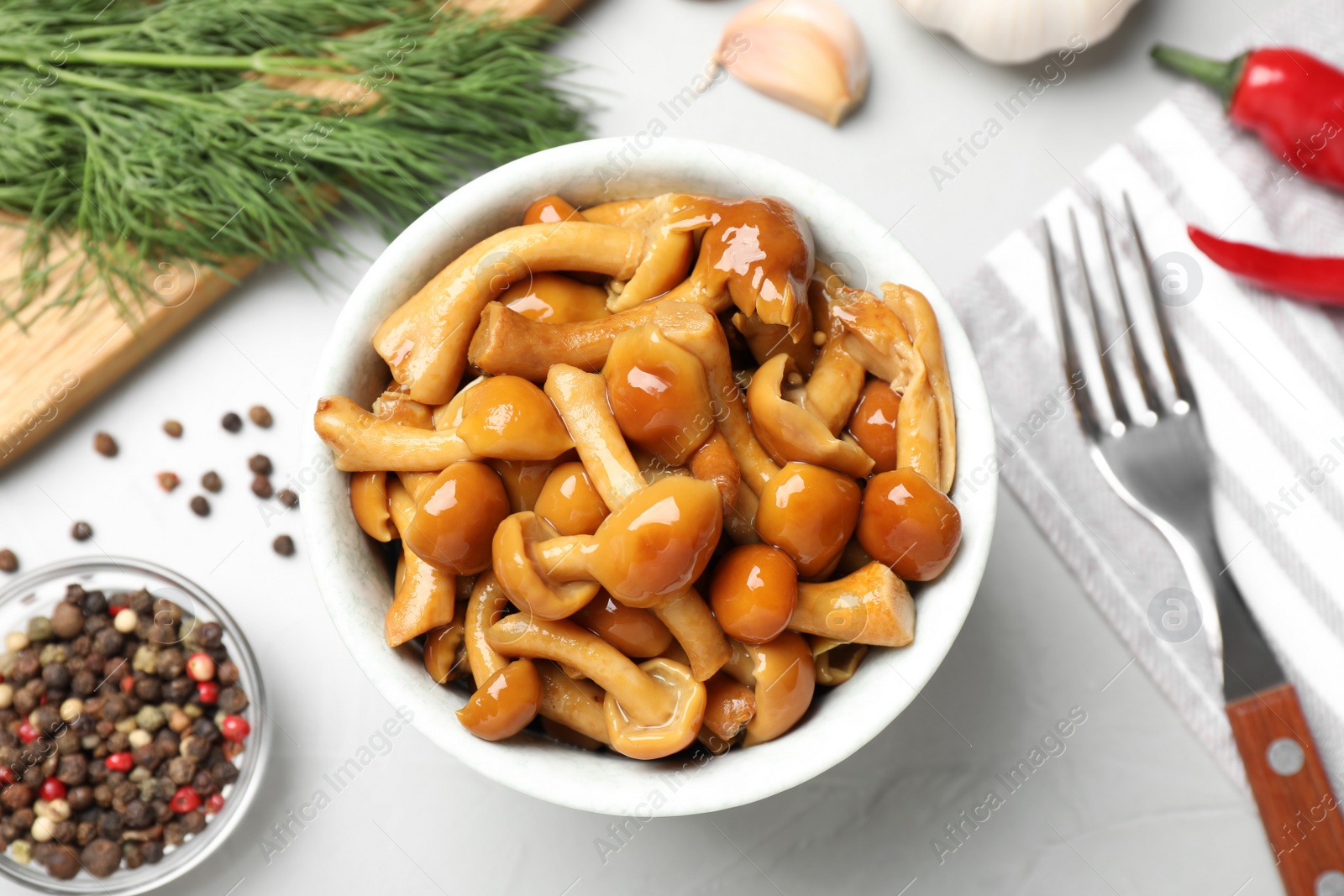 Photo of Tasty marinated mushrooms, garlic and dill on grey table, flat lay