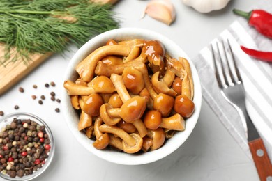 Tasty marinated mushrooms, garlic and dill on grey table, flat lay