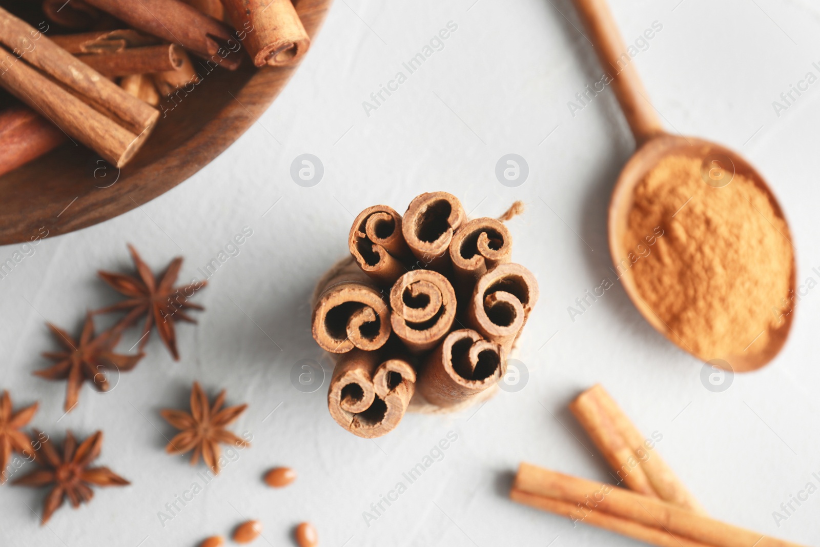 Photo of Tied cinnamon sticks on light background, closeup