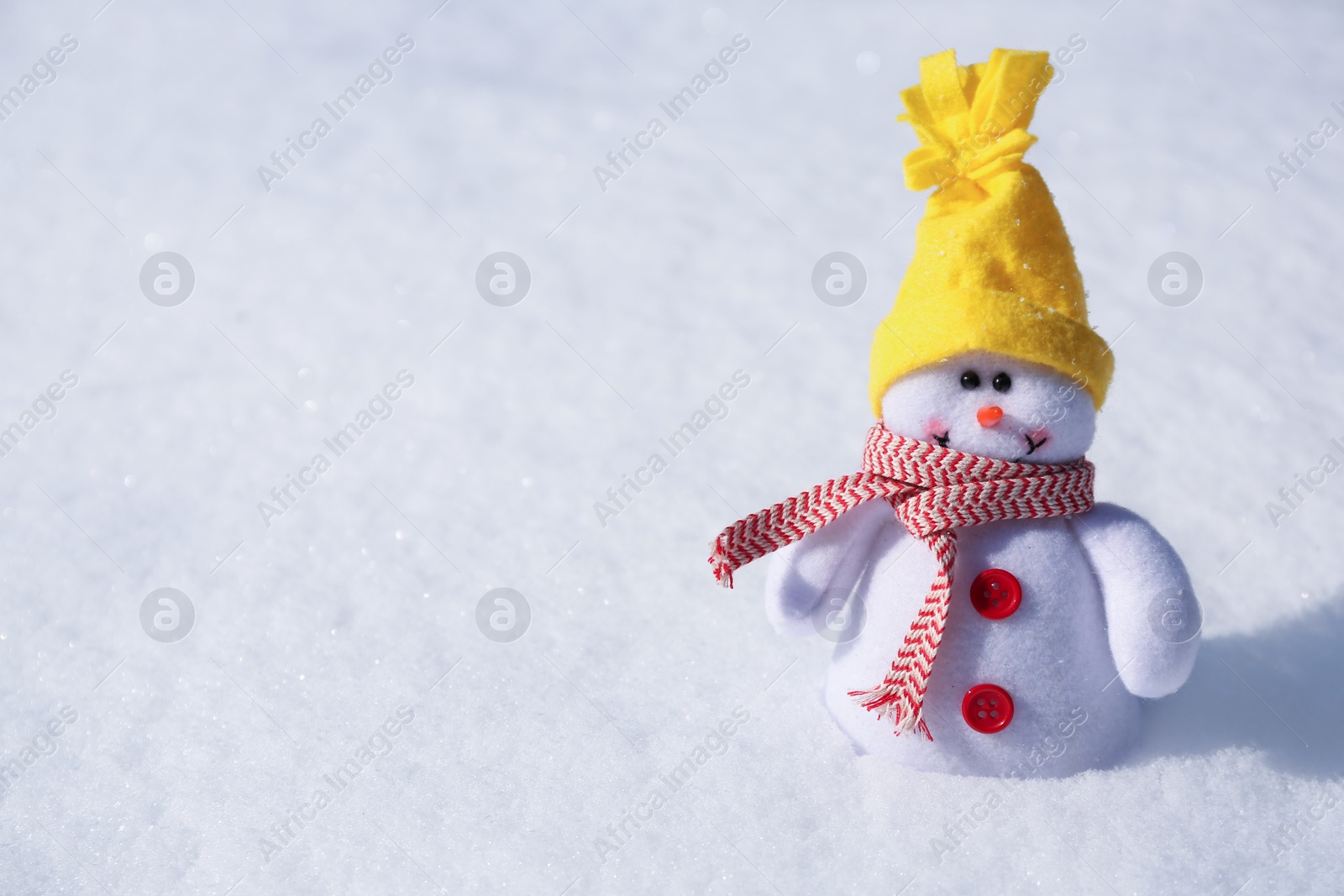 Photo of Cute small decorative snowman on snow outdoors, space for text