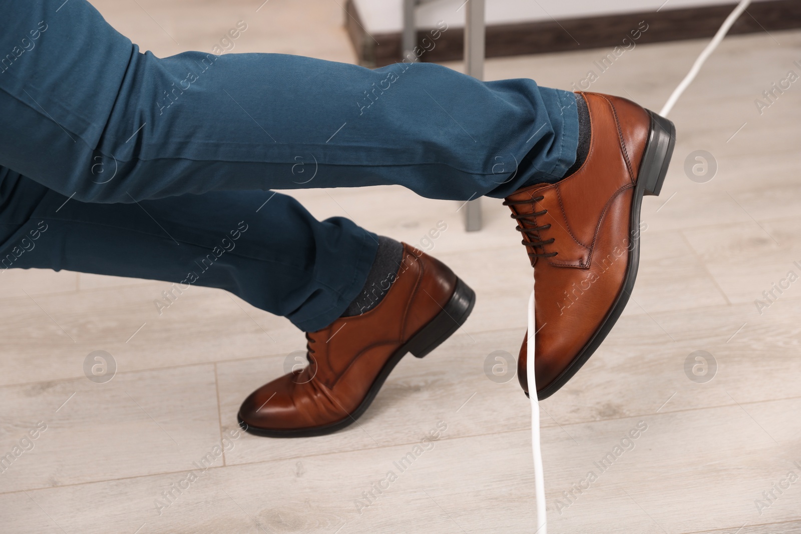 Photo of Man tripping over cord in office, closeup