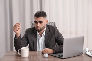 Photo of Sad businessman sitting at table in office