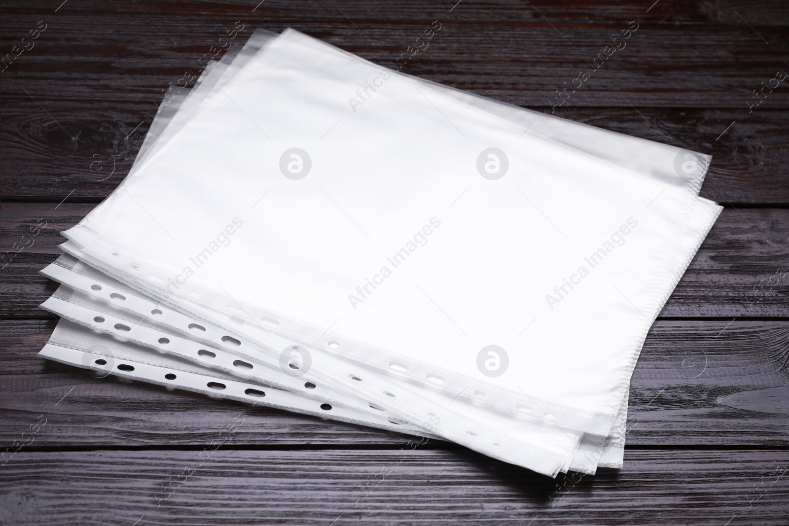 Photo of Punched pockets on brown wooden table, closeup