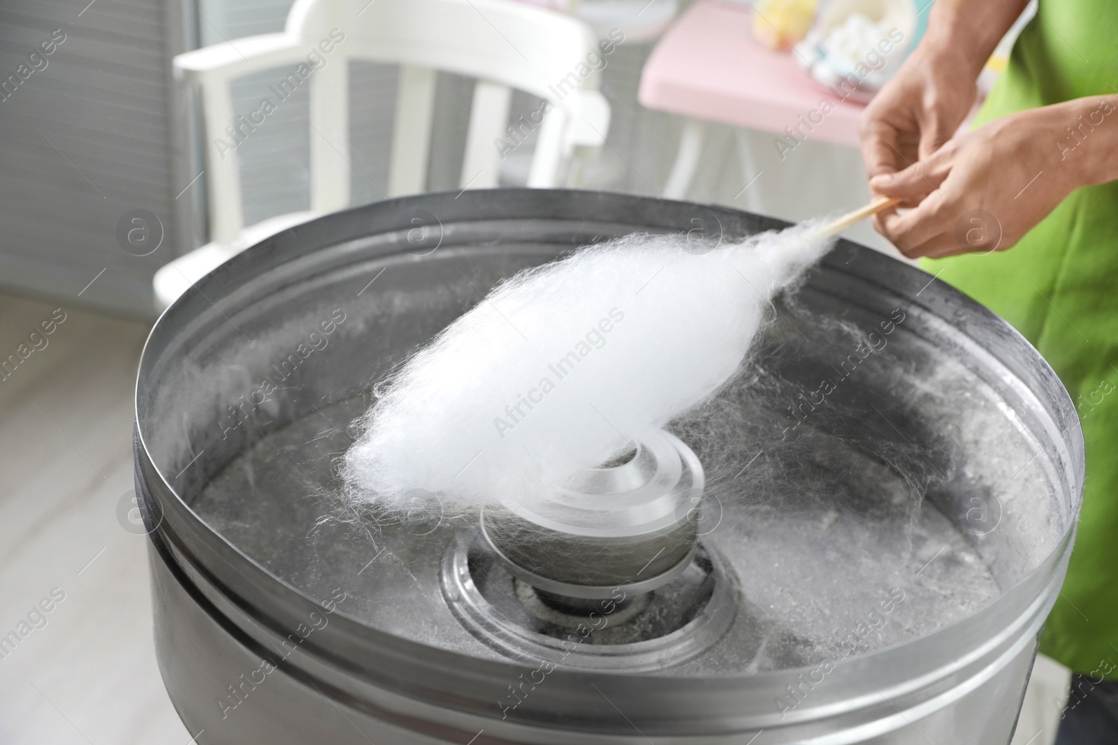 Photo of Woman making cotton candy using modern machine indoors, closeup