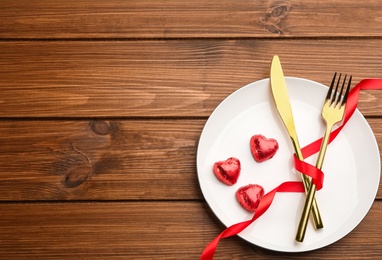 Beautiful table setting on wooden background, top view with space for text. Valentine's Day dinner