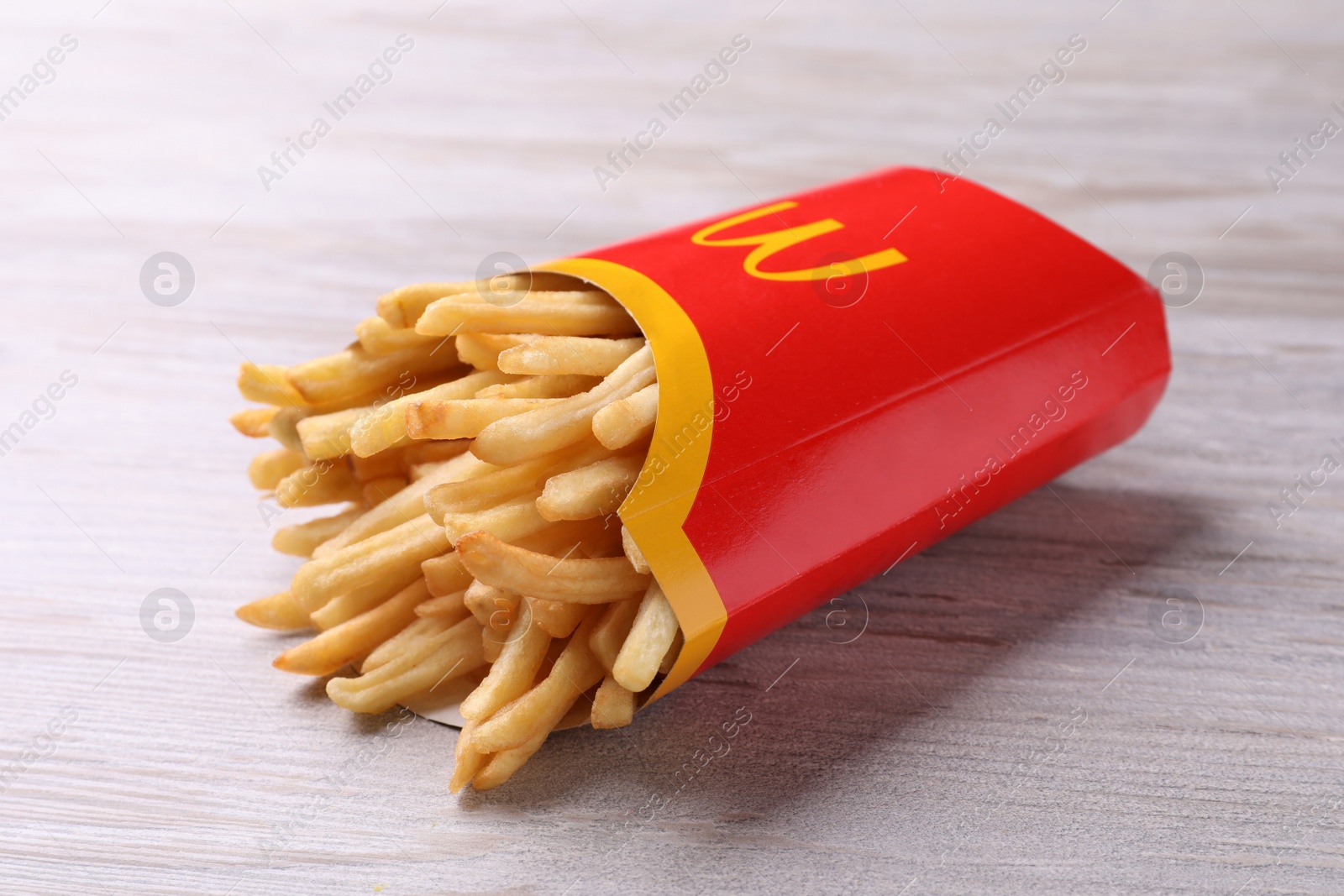 Photo of MYKOLAIV, UKRAINE - AUGUST 12, 2021: Big portion of McDonald's French fries on white wooden table