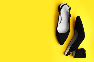 Photo of Stylish female shoes on yellow background, flat lay. Space for text