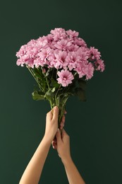 Photo of Woman holding beautiful bouquet near green chalkboard. Happy Teacher's Day