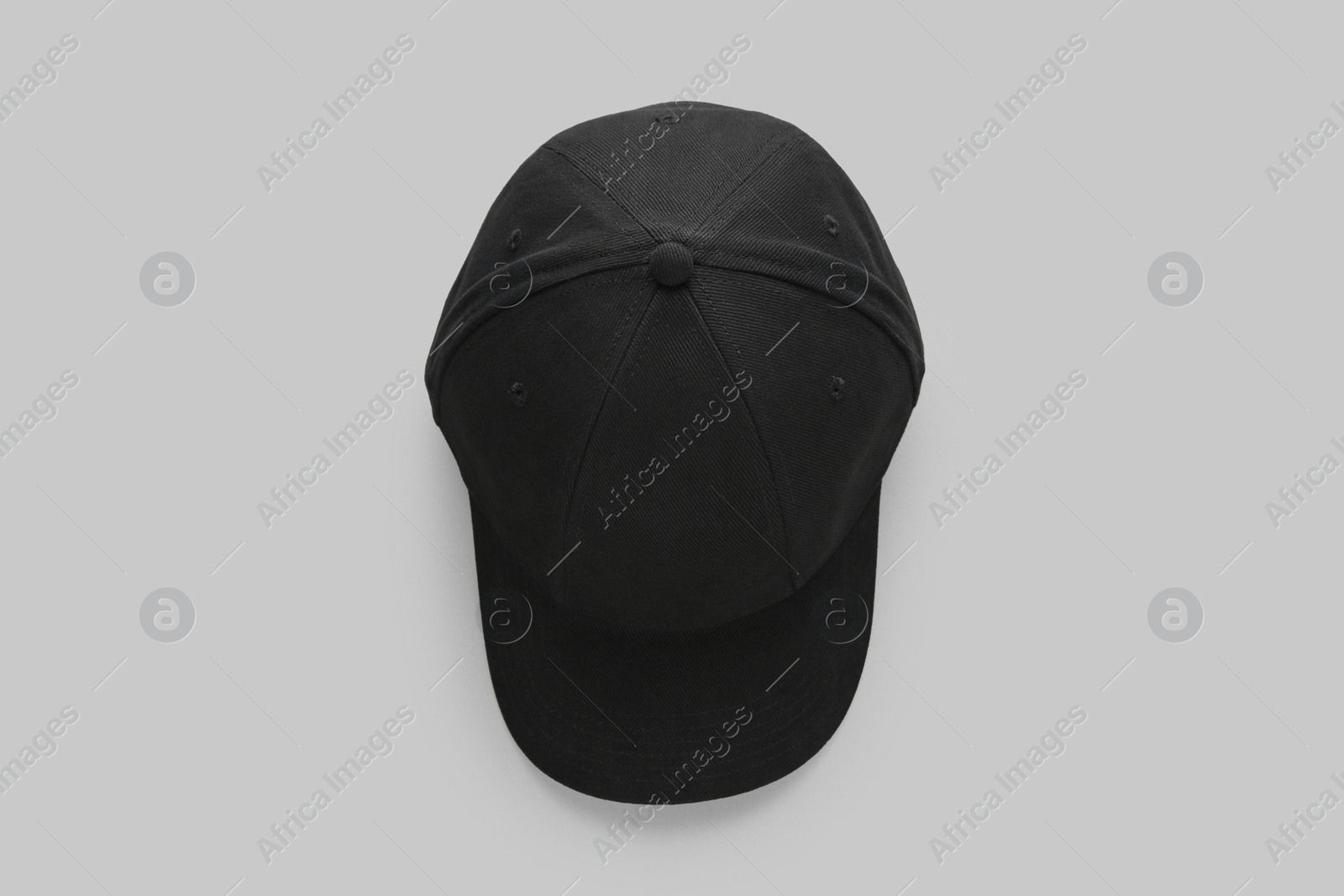 Photo of Stylish black baseball cap on light grey background, top view