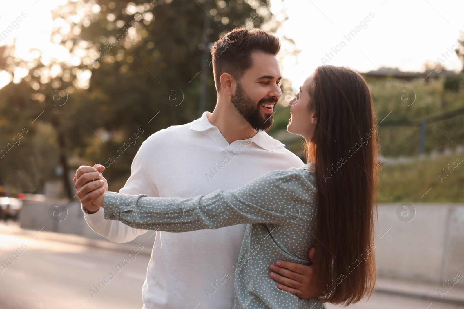 Photo of Lovely couple dancing together outdoors at sunset