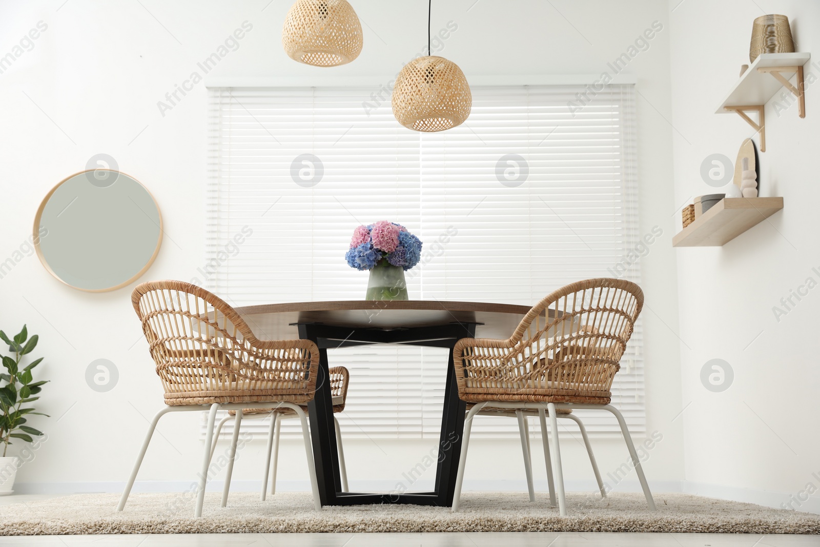 Photo of Table, chairs and vase of hydrangea flowers in dining room, low angle view. Stylish interior