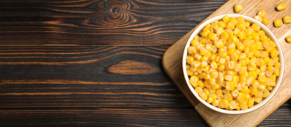 Delicious canned corn and space for text on wooden table, flat lay. Banner design