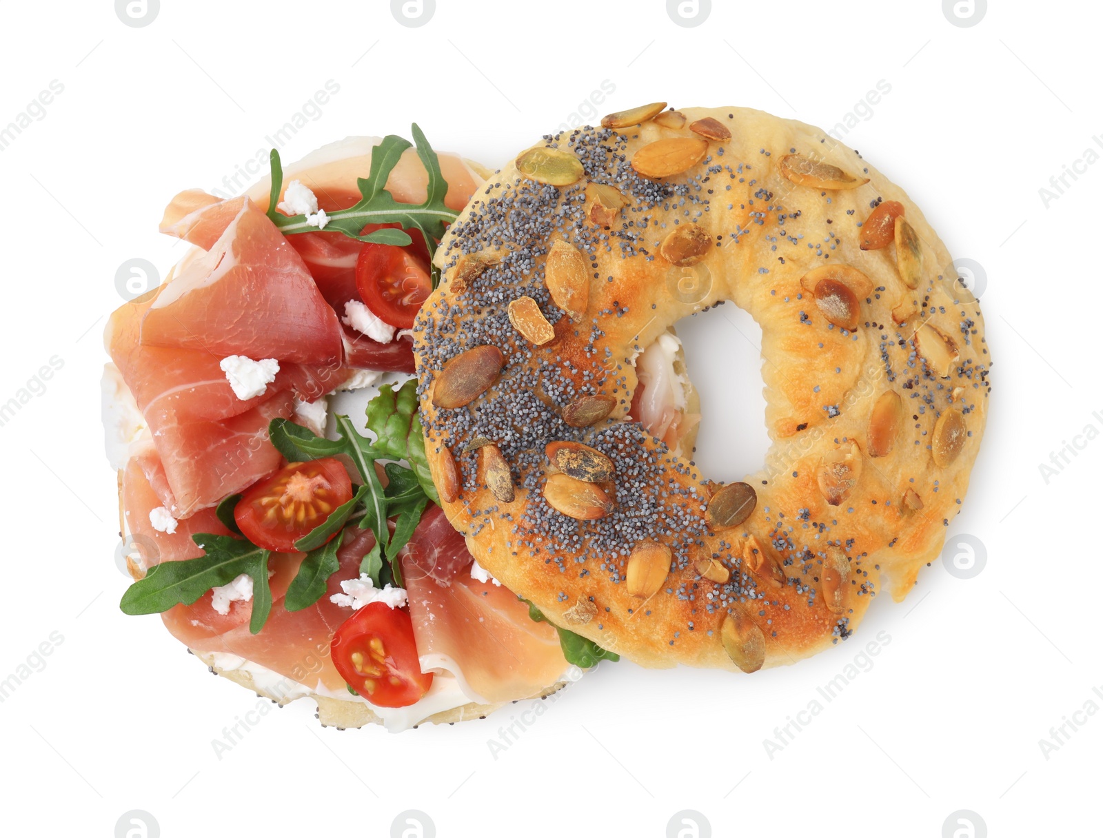 Photo of Tasty bagel with cured ham, arugula, cream cheese and tomatoes isolated on white, top view