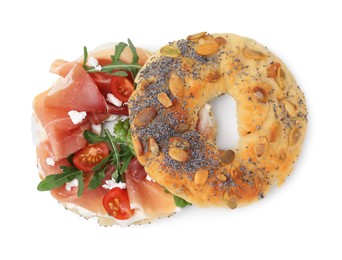 Tasty bagel with cured ham, arugula, cream cheese and tomatoes isolated on white, top view