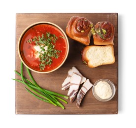 Photo of Delicious borsch served with pampushky, green onions and salo isolated on white, top view. Traditional Ukrainian cuisine