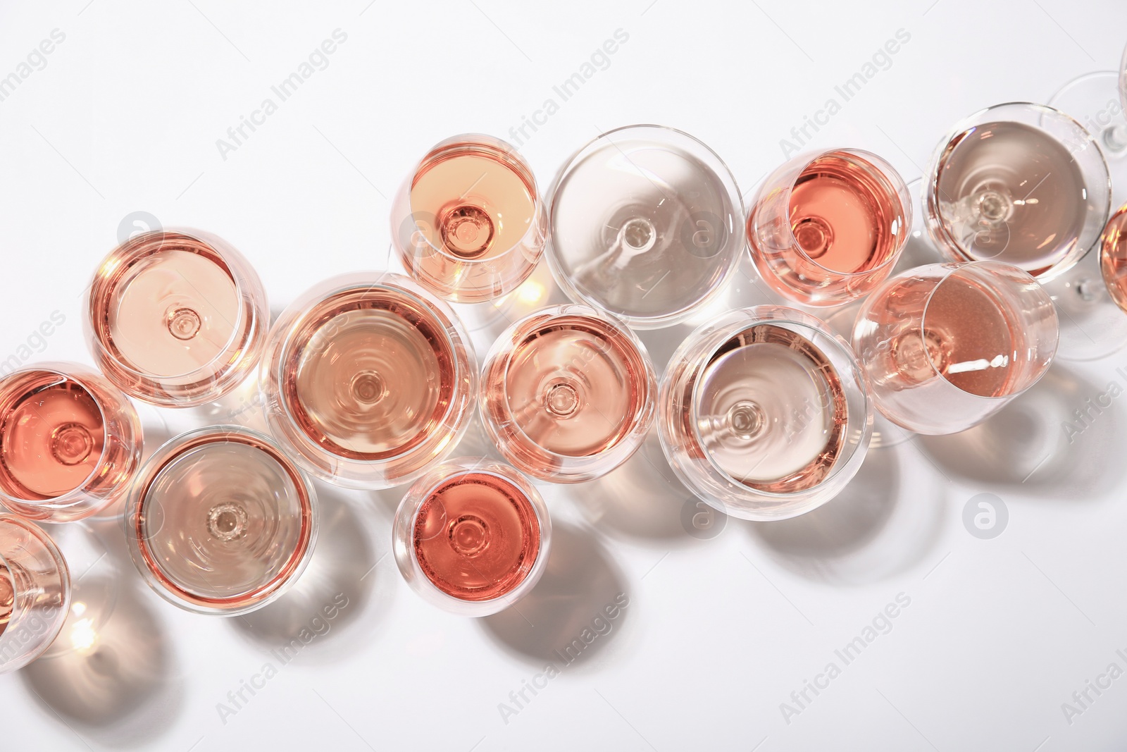 Photo of Different glasses with rose wine on white background, top view