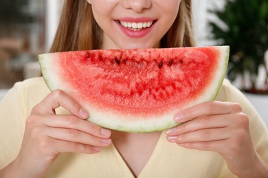 Photo of Teenage girl with slice of watermelon indoors, closeup