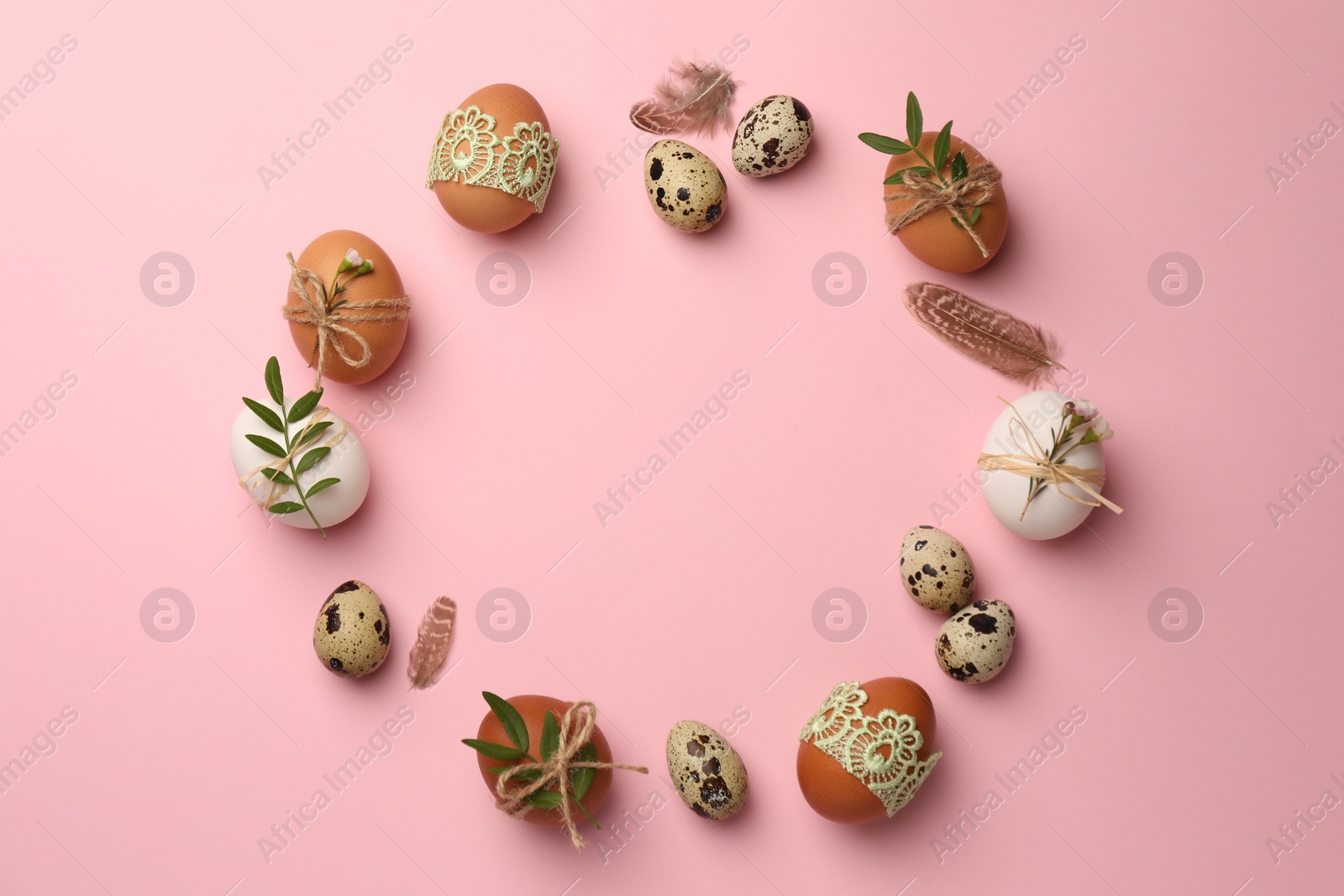 Photo of Frame made of festively decorated eggs and natural decor on pink background, top view with space for text. Happy Easter