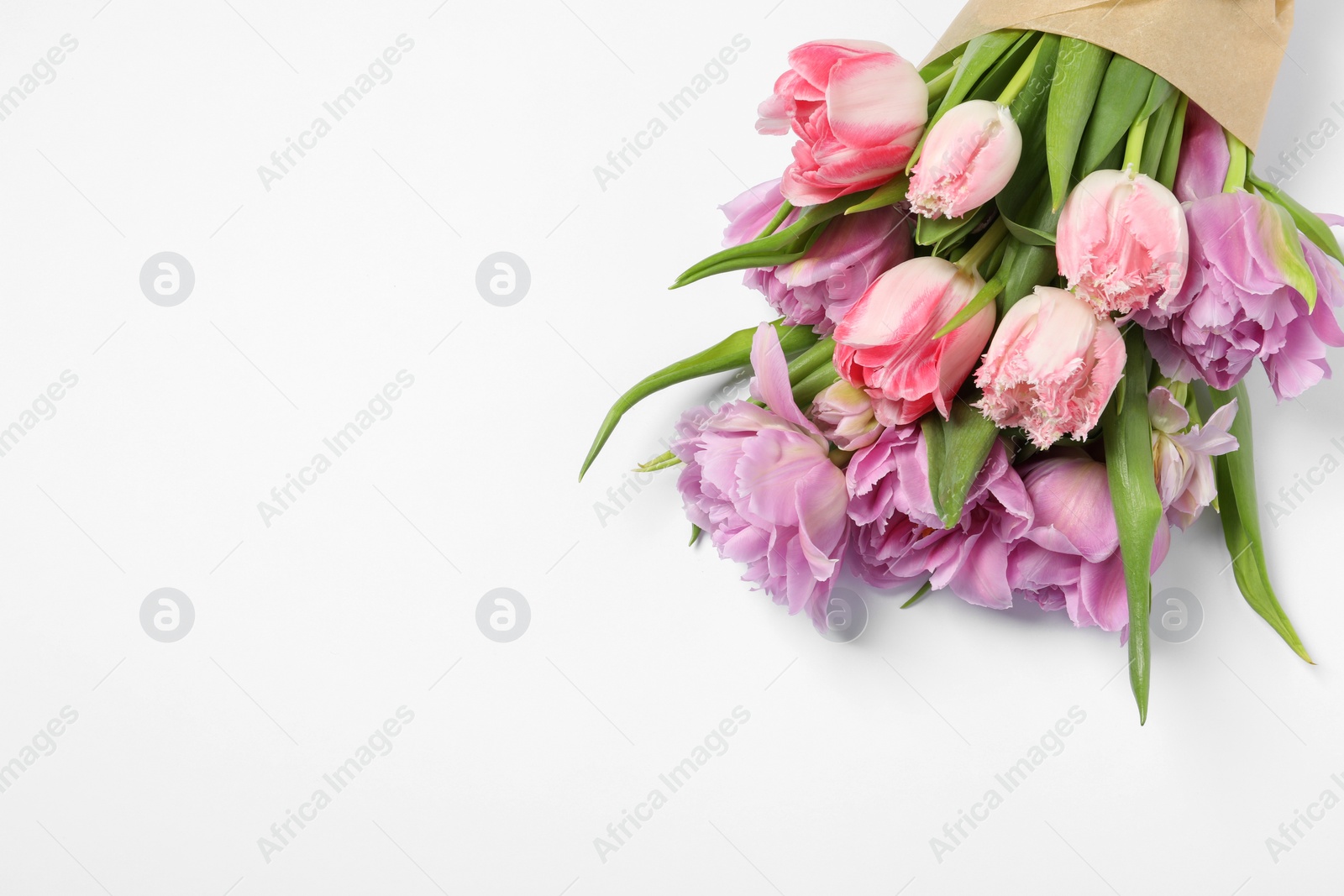 Photo of Beautiful bouquet of colorful tulip flowers on white background, top view. Space for text