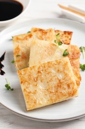 Photo of Delicious turnip cake served on white wooden table