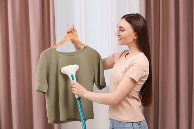 Woman steaming shirt on hanger at home