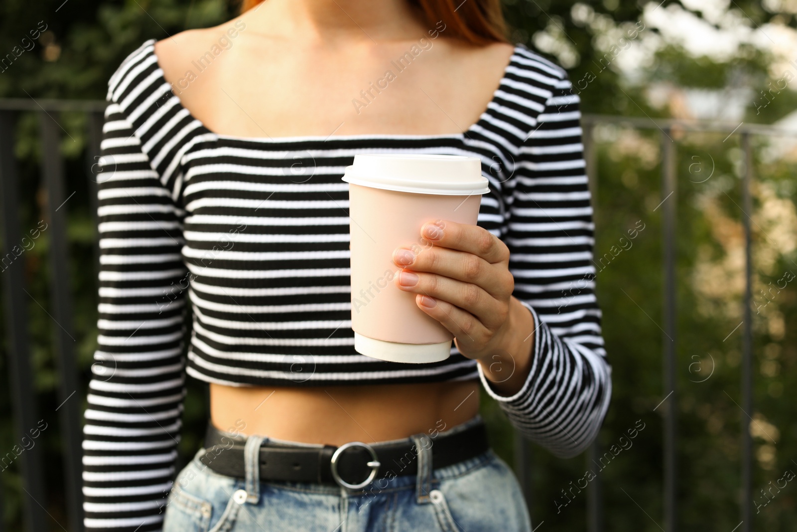 Photo of Coffee to go. Woman with paper cup of drink outdoors, closeup