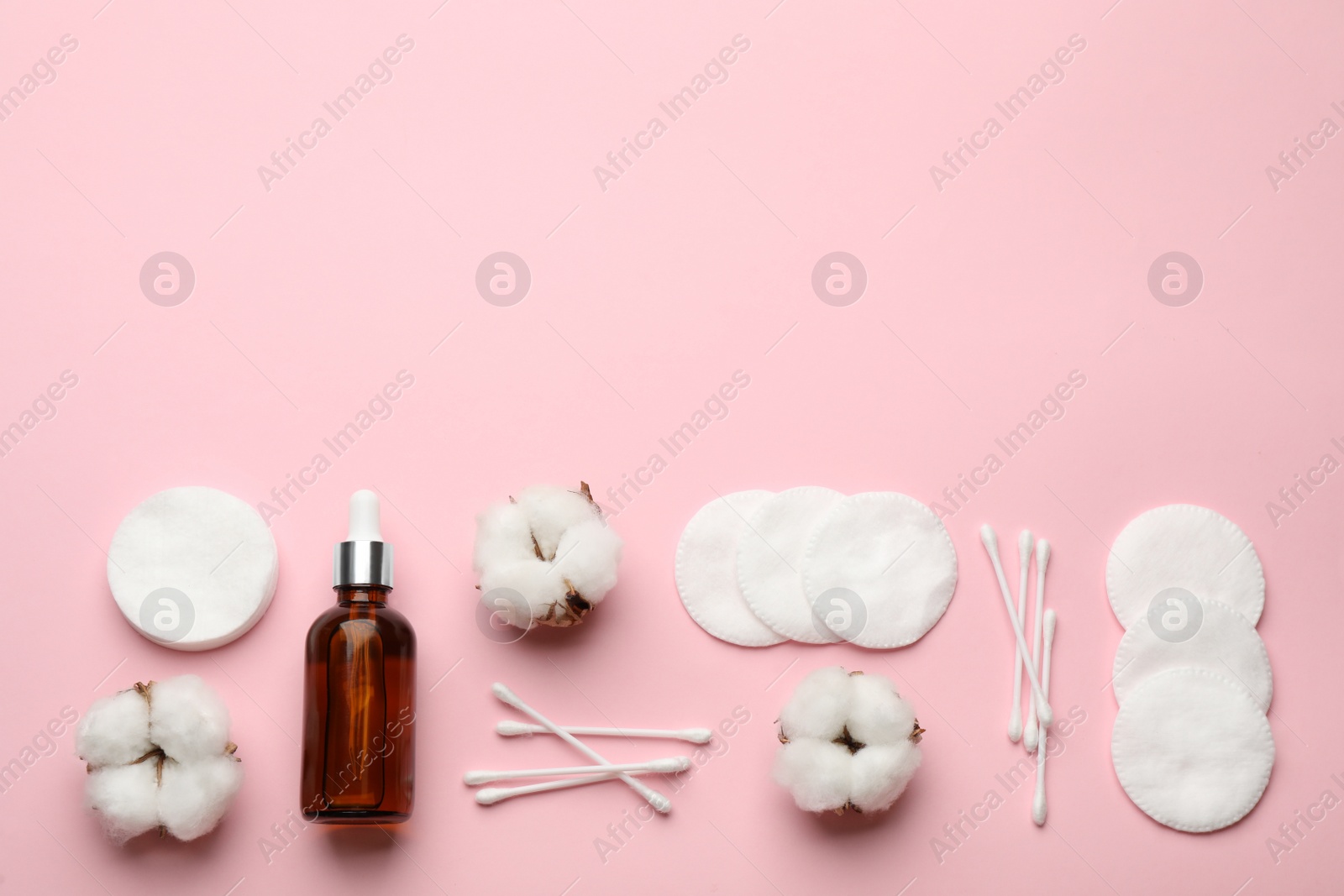 Photo of Cotton pads, swabs, flowers and makeup removal product on pink background, flat lay. Space for text