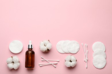 Photo of Cotton pads, swabs, flowers and makeup removal product on pink background, flat lay. Space for text