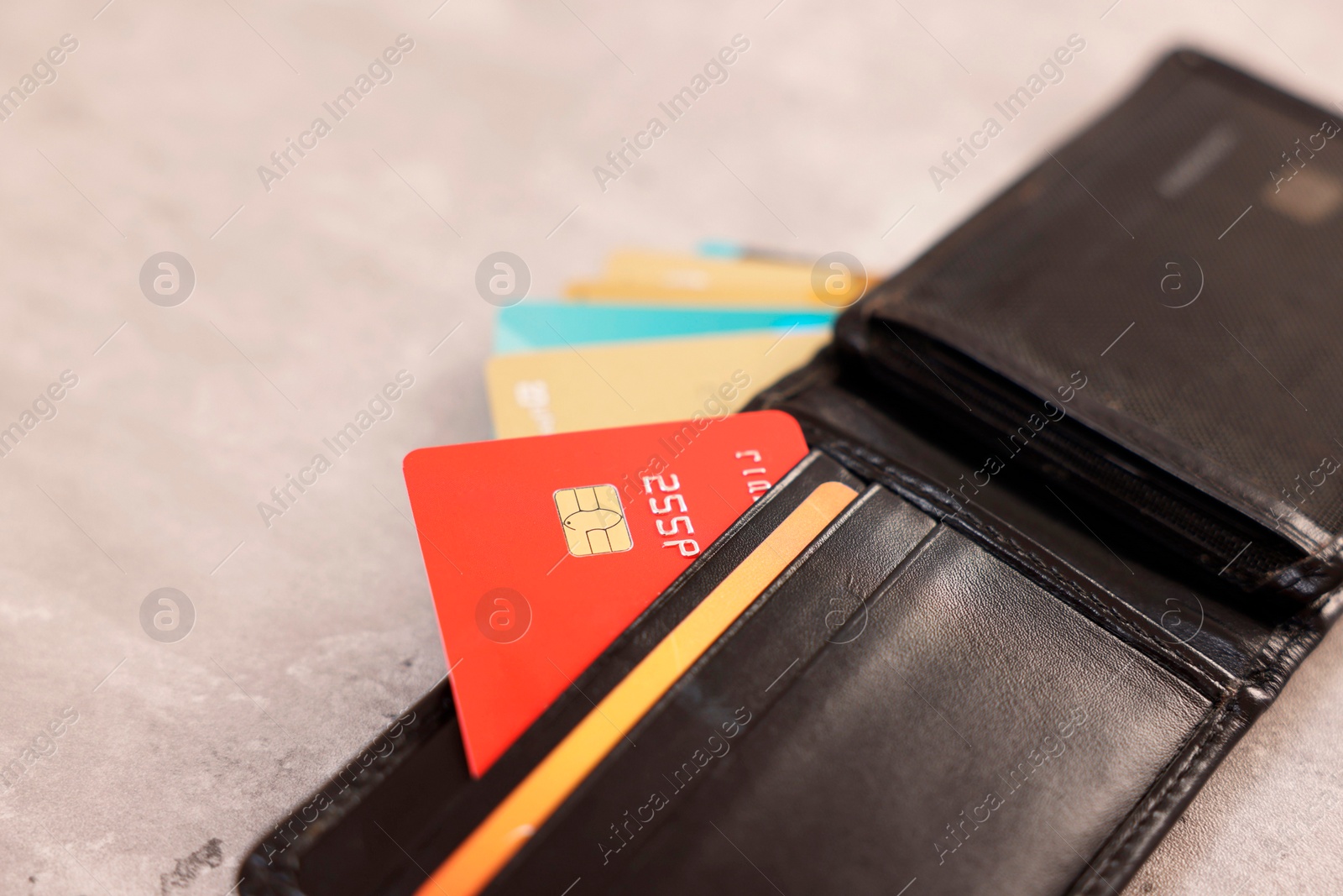 Photo of Many different credit cards and leather wallet on grey table, closeup