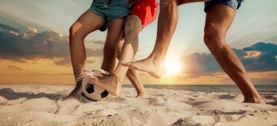 Image of Friends playing football on beach during sunset, closeup. Banner design