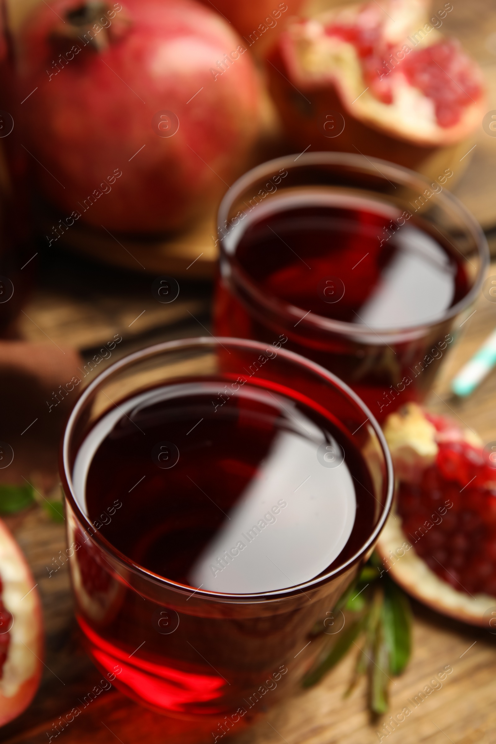 Photo of Pomegranate juice on wooden table, closeup view