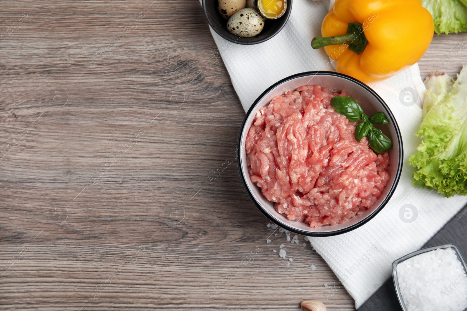 Photo of Raw chicken minced meat and ingredients on wooden table, flat lay. Space for text