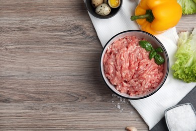 Raw chicken minced meat and ingredients on wooden table, flat lay. Space for text