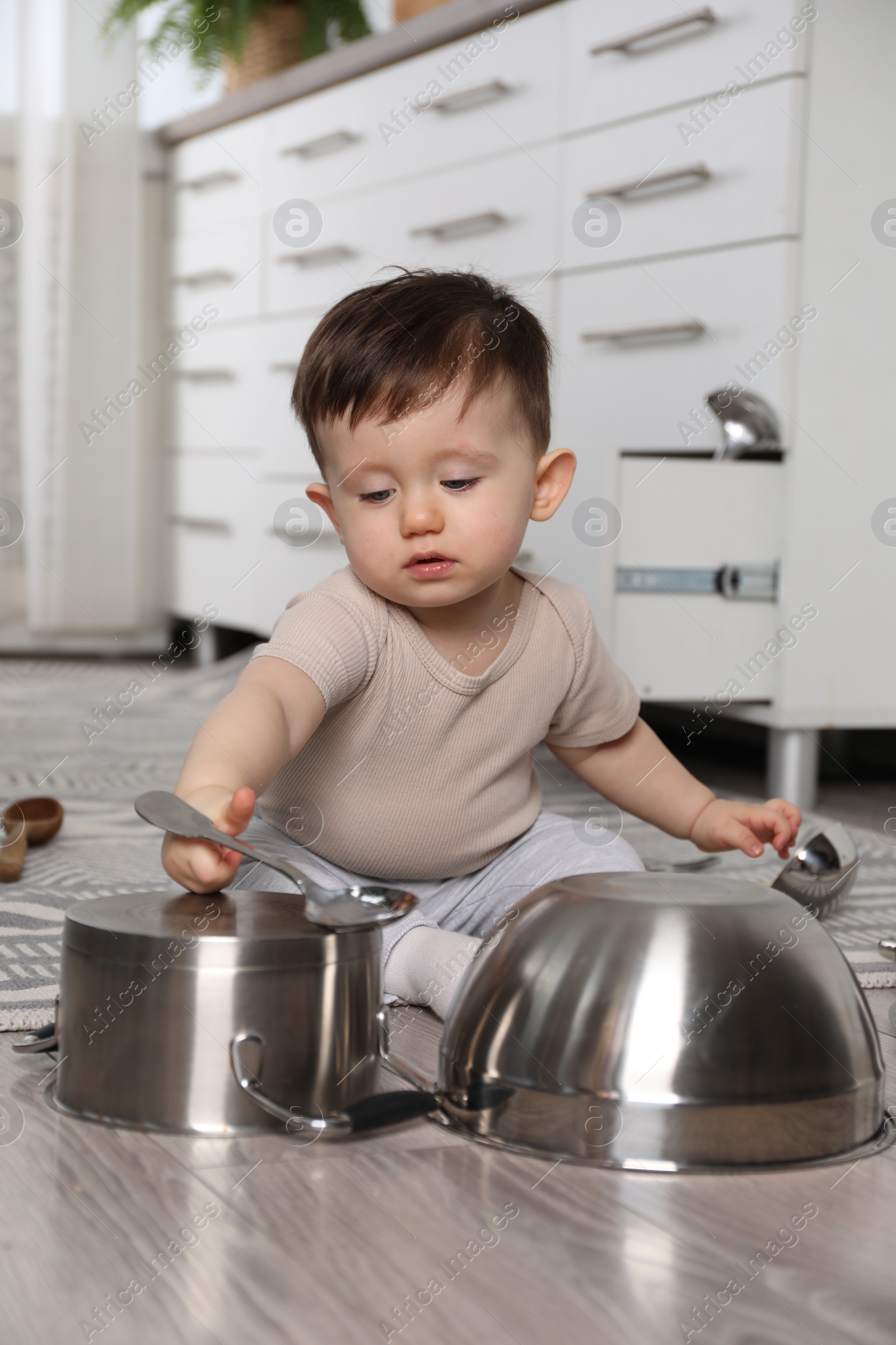 Photo of Cute little boy with cookware at home