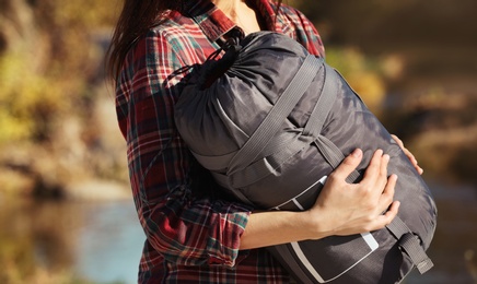 Photo of Female camper with sleeping bag outdoors, closeup