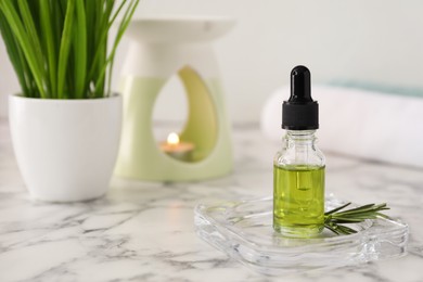 Aroma lamp and coniferous essential oil on white marble table, space for text