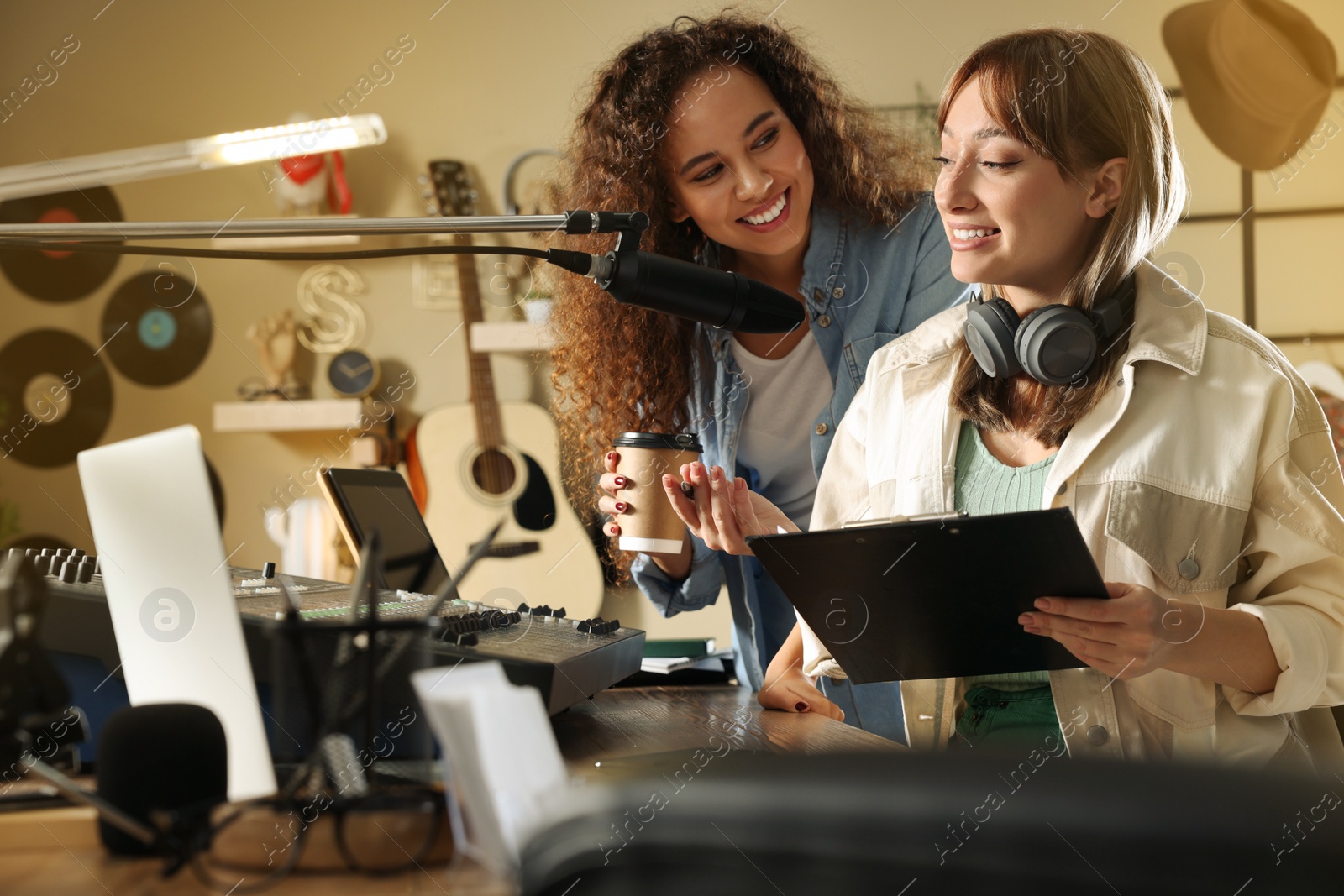 Photo of Young women working in modern radio studio