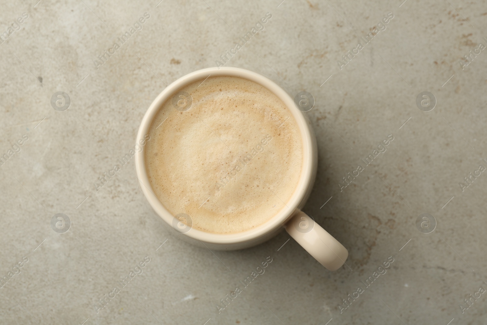 Photo of Cup of aromatic coffee on grey table, top view