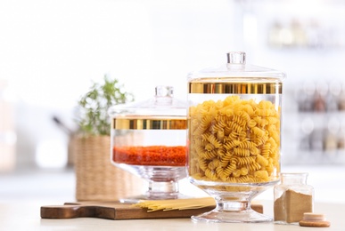 Jars with foodstuff on wooden table in modern kitchen