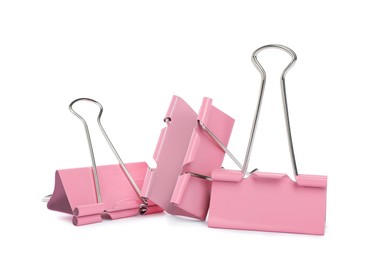 Photo of Pink binder clips on white background. Stationery item